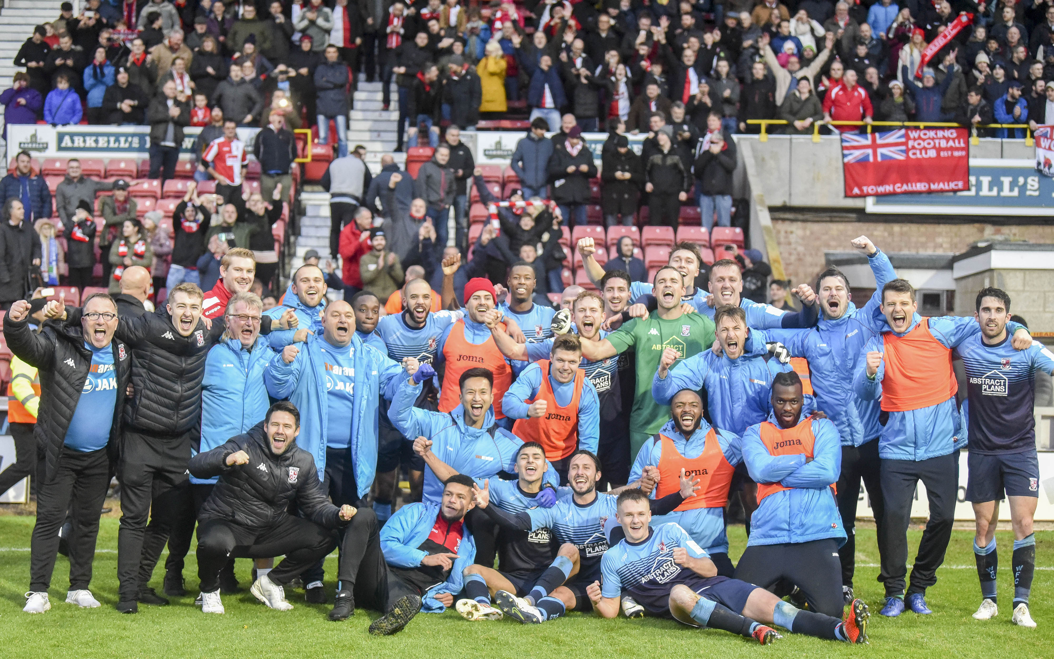 Woking players and fans celebrate a historic day in Swindon